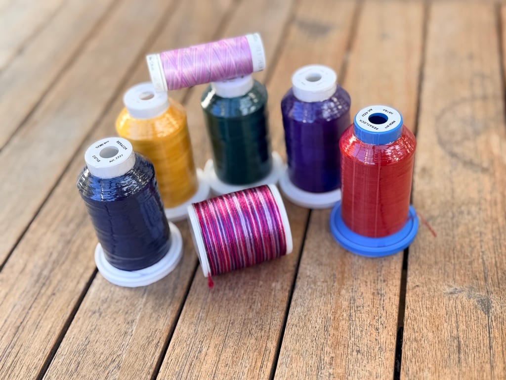 Fünf bunte Garnkonen Mettler Seraflock aus dem Materialpaket zum Coverstitch-Kurs